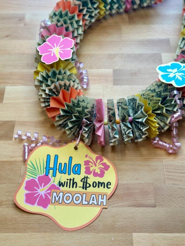 money lei with printable Hawaiian flowers and a sign that says "hula with some moolah"
