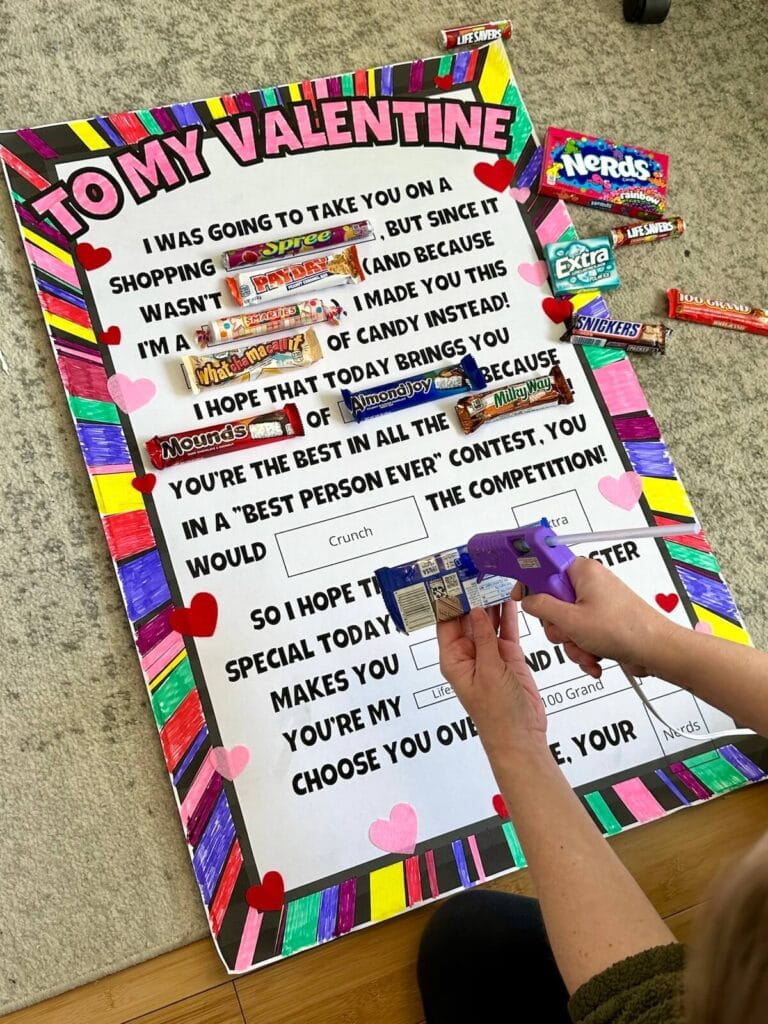 gluing candy bars on a Valentine candy poster