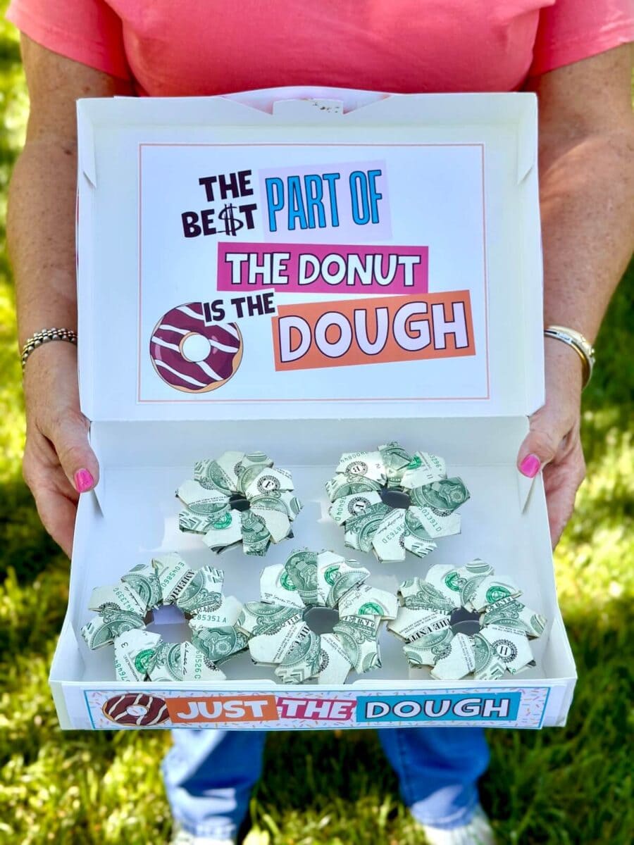 dollar bills folded in the shapes of donuts inside a donut box