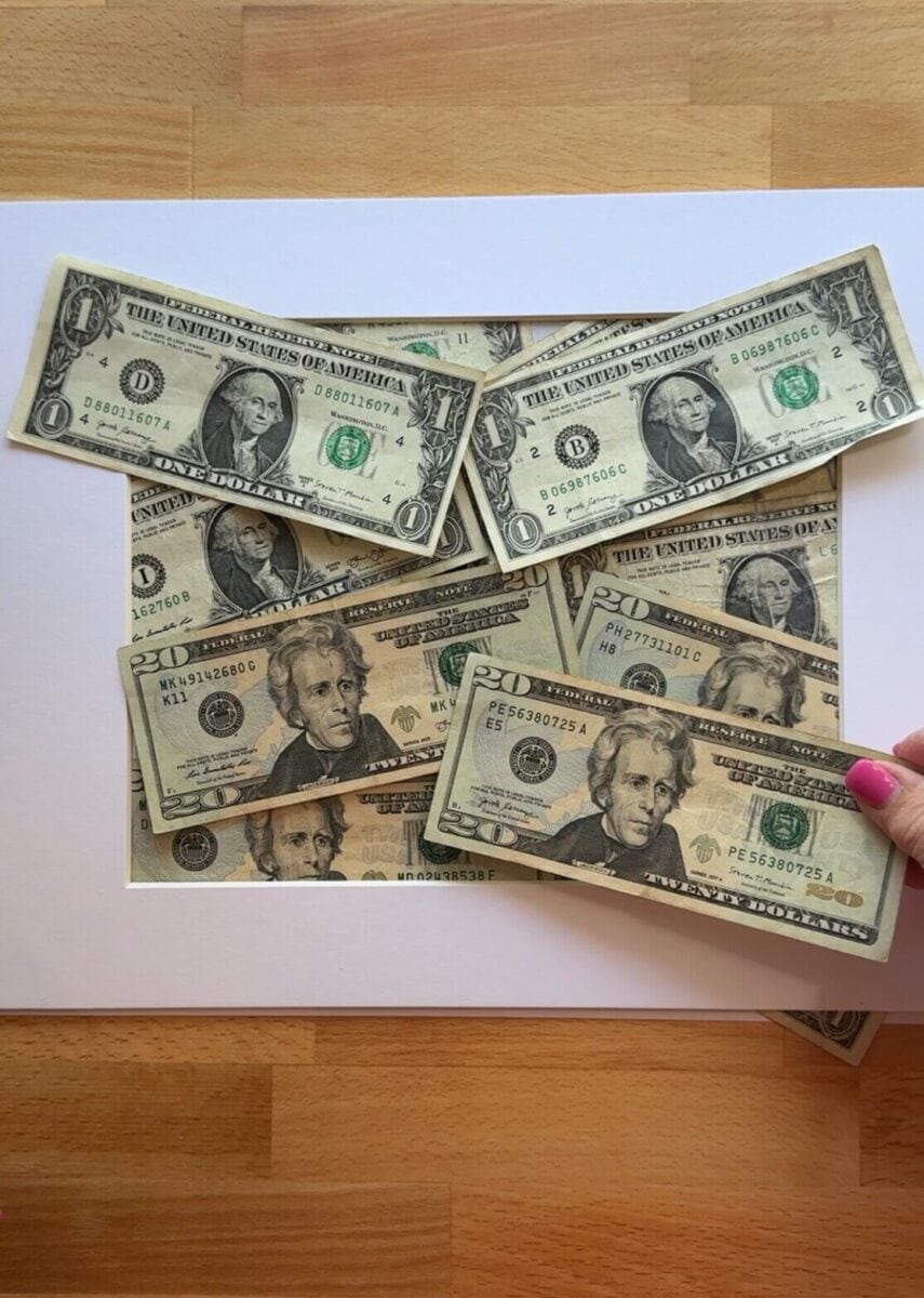 placing cash bills in a picture frame