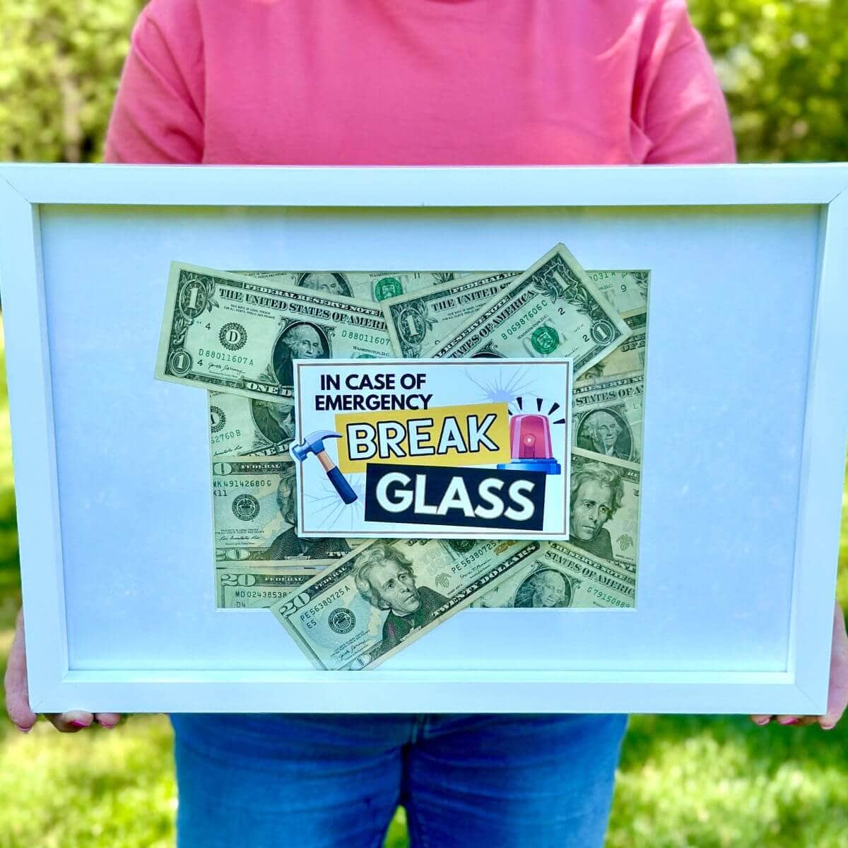 picture frame with money inside and a sign on top that says "in case of emergency break glass"