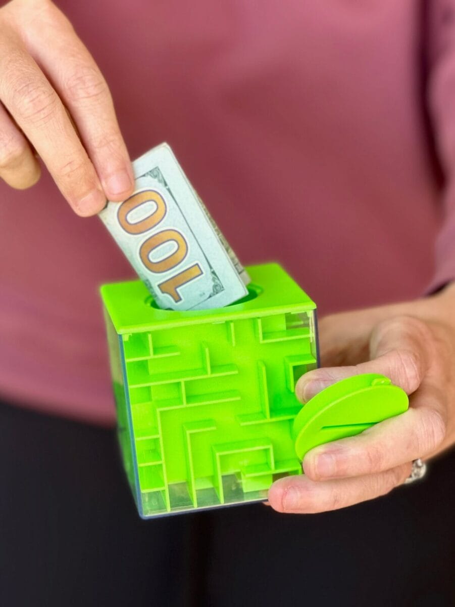 woman pulling a one hundred dollar bill out of a maze puzzle box