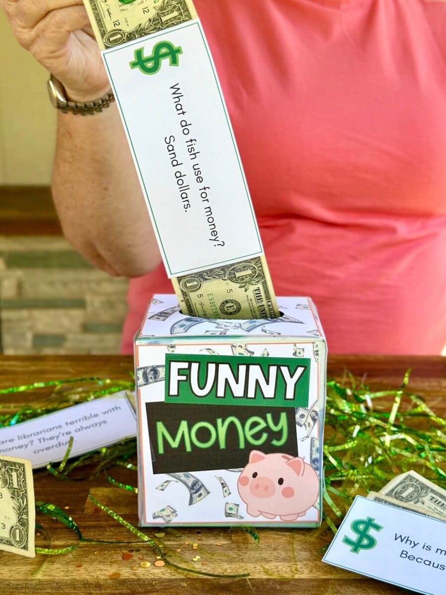 woman pulling dollar bills out of a tissue box that has a "funny money" sign on it