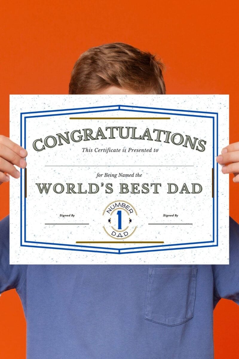 boy holding a certificate for the World's Best Dad