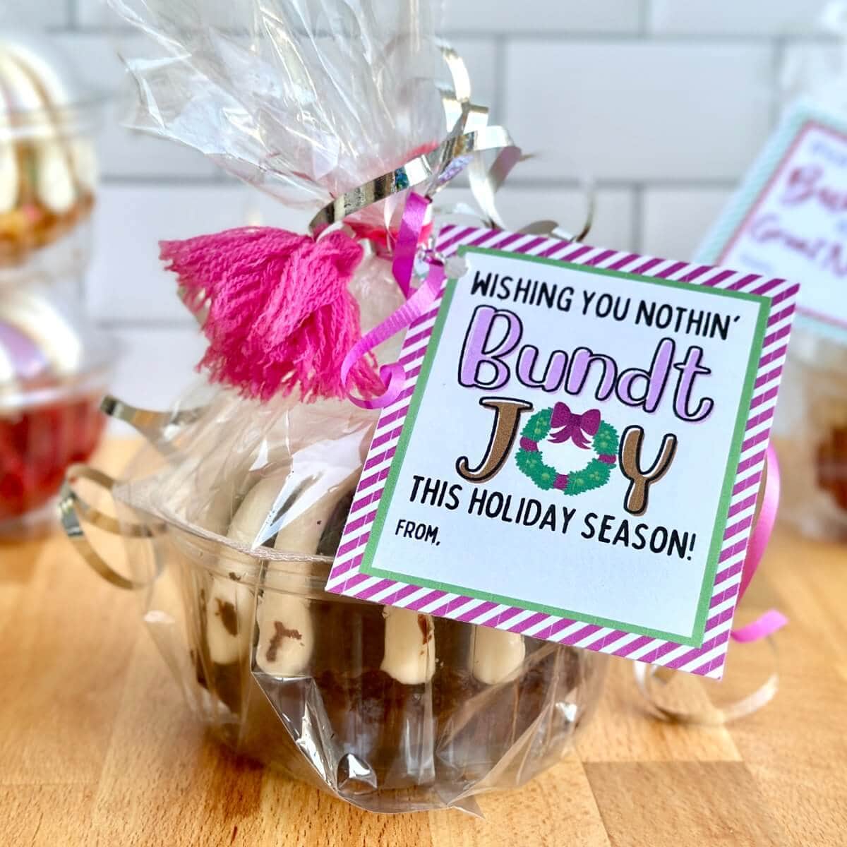 mini bundt cake wrapped in cellophane with a printable tag for a Christmas neighbor gift