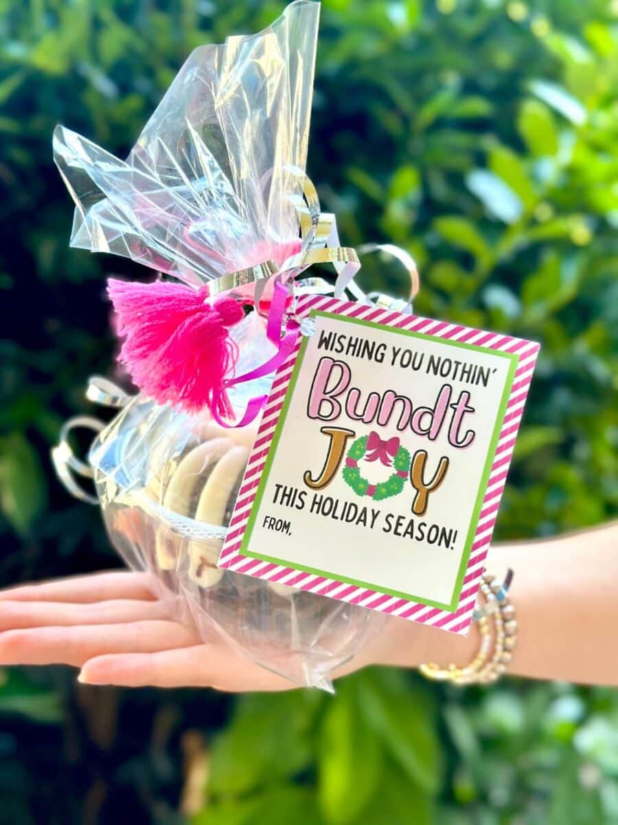 mini bundt cake wrapped in cellophane with a printable tag for a Christmas neighbor gift