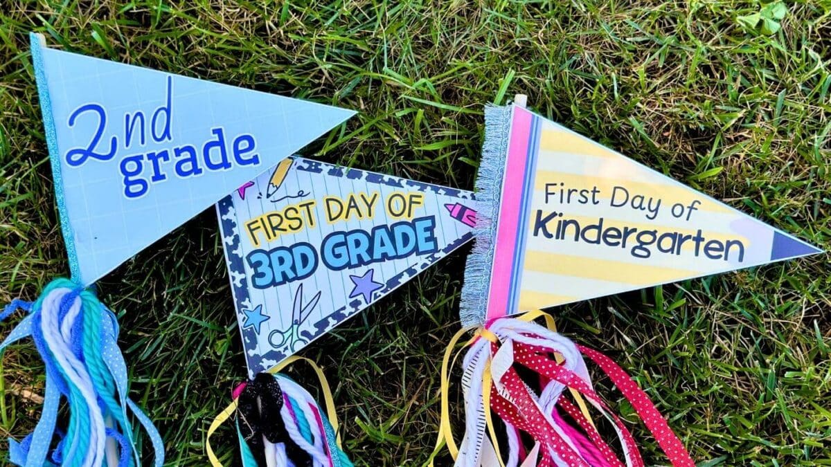 3 colorful first day of school pennant flags on dowels with ribbon hanging down