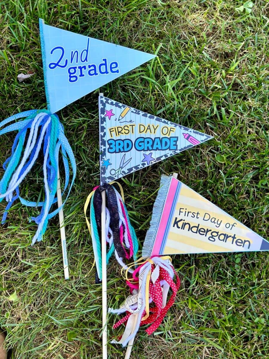 3 colorful first day of school pennant flags on dowels with ribbon hanging down