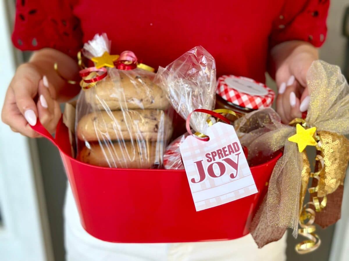spread joy Christmas gift tag tied on a gift basket with bagels and jar of jam