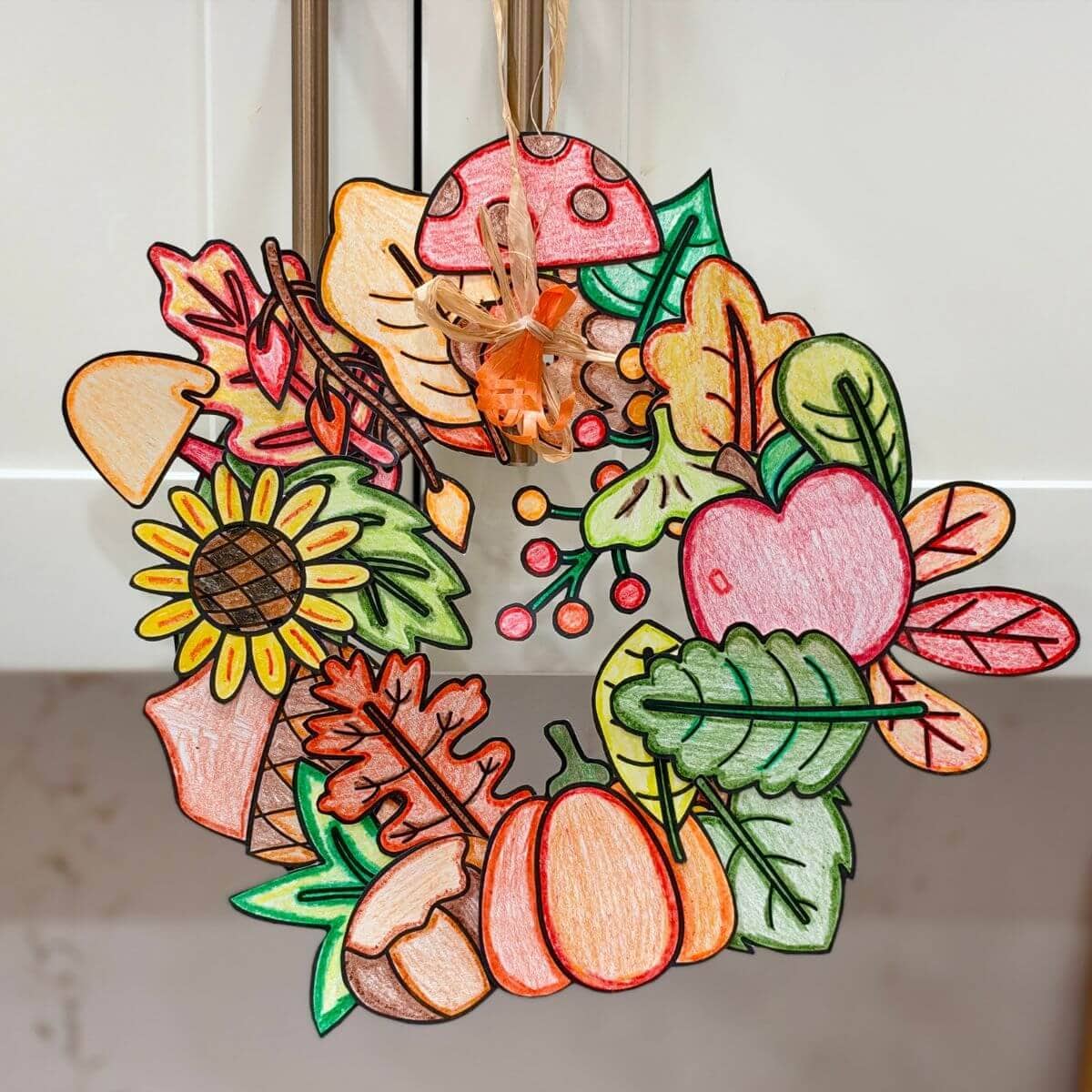 Fall wreath craft made with printable Fall leaves, pumpkins, acorns, and more Fall designs to color, cut, and paste